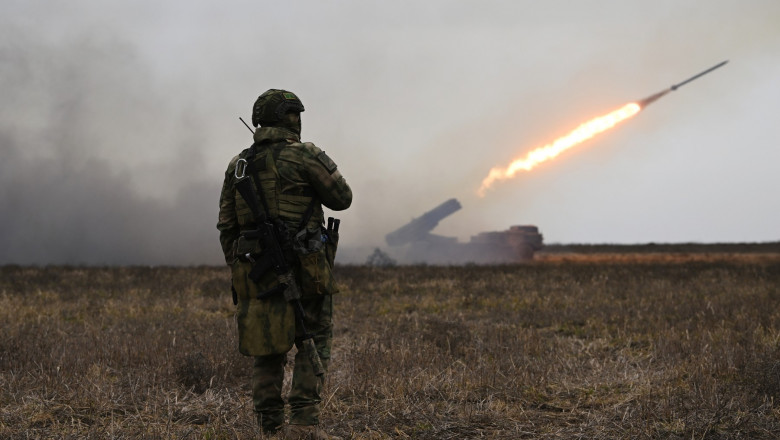 militar rus lângă un lansator de rachete de tip Katiușa „Uragan”