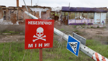 un panou rosu pe care scrie cu alb pericol de mine, in ucraina