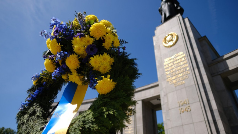 Un buchet de flori cu o panglică în culorile steagului ucrainean este depus la monumentul din Treptow, Berlin, Germania, ridicat în memoria soldaților sovietici care au murit în al Doilea Război Mondial pe 8 mai 2022.