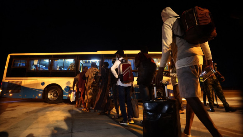 Studenți nigerieni stau la coadă să urce într-un autobuz în timpul operațiunii de evacuare a acestora din Sudanul cuprins de război civil, pe 4 mai 2023.