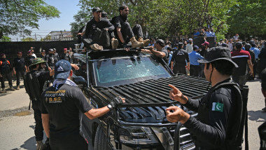 forțe de securitate pakistaneze escortează mașina cu care fotul premier Inmar Khan a fost adus la Curtea Supremă