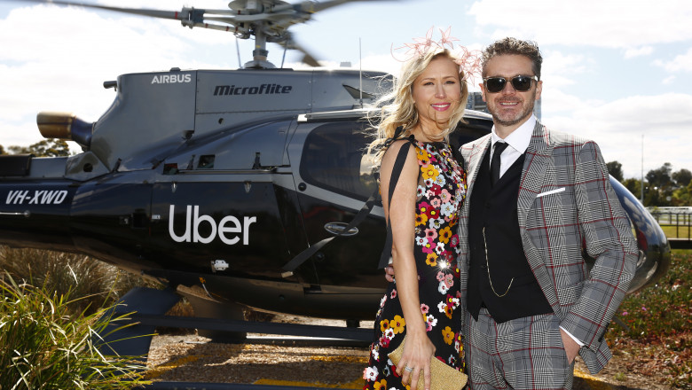 Cuplu în fața unui elicopter pe care scrie uber
