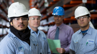 Workers and businessman in metal plant