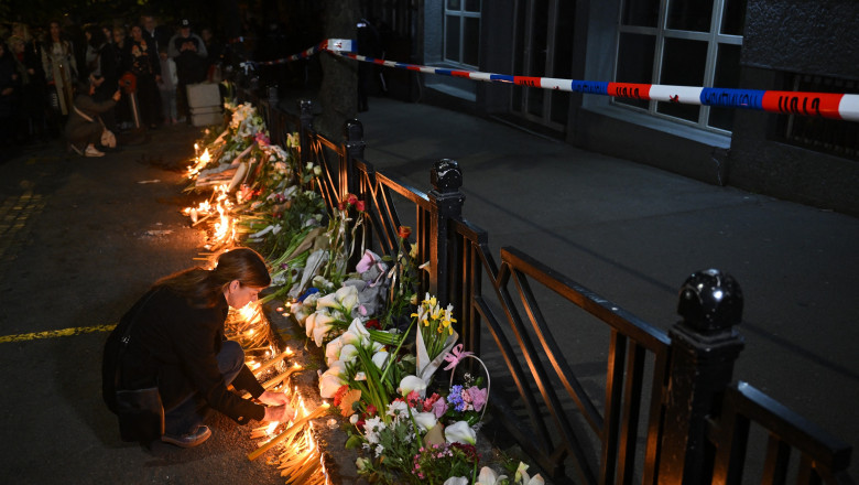 oameni aprind lumânări în fața școlii din Belgrad unde au fost uciși 8 elevi și un gardian