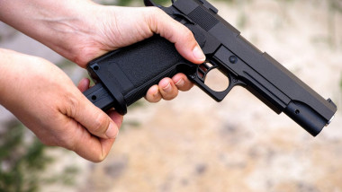 O persoană ține în mâini un pistol de tip airsoft.