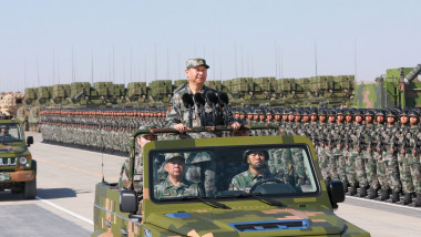 Președintele Chinei Xi Jinping călătorește în picioare într-un automobil militar în cadrul unei ceremonii militare la Beijing, pe 30 septembrie 2023.