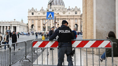Un polițist montează un gard de securitate în Vatican, pe 13 mai 2023.