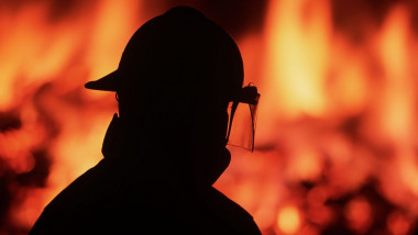silueta unui pompier care intervine la un incendiu