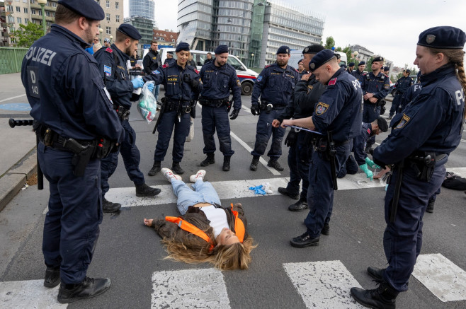 protestatara intinsa pe spate pe asfalt, în timp ce polițiști privesc