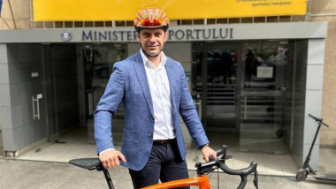 Eduard Novak, ministrul Sportului, pozează în fața sediului ministerului din București ținând în fața o bicicletă, pe 26 mai 2023.