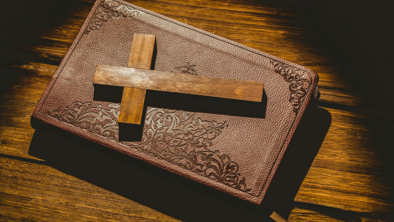 Crucifix icon on the bible on wooden table