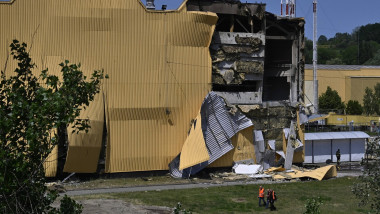 People walk near the damaged industrial building that was damaged in an attack by the Iranian Shahed attack drone of the Russian army in Kyiv.