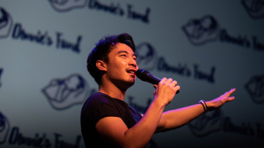 comediantul malaezian Nigel Ng, în timpul unui show de stand-up cu un microfon într-o mână
