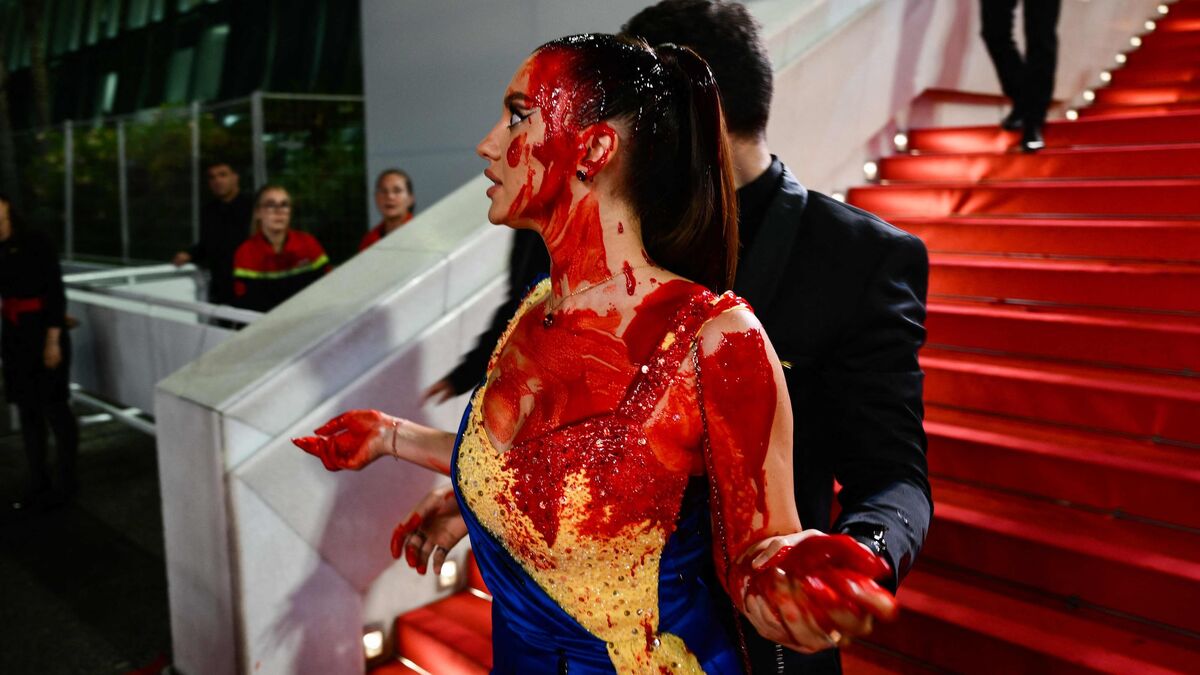 Protest la festivalul de film de la Cannes. O femeie îmbrăcată în culorile steagului ucrainean s-a stropit cu vopsea roșie