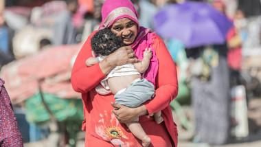 O refugiată din Sudan trece granița în Etiopia ținându-și copilul în brațe pe 4 mai 2023.