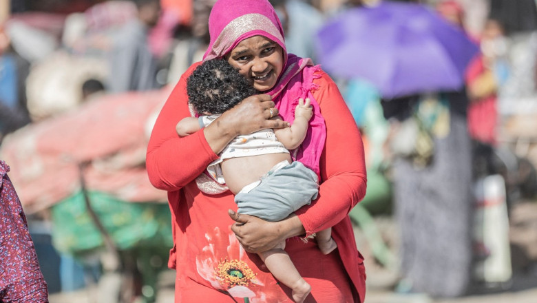 O refugiată din Sudan trece granița în Etiopia ținându-și copilul în brațe pe 4 mai 2023.