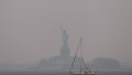 Statuia Libertății din NEw York este învăluită de un fum portocaliu, pe 6 iunie, din cauza incendiilor de vegetație din Canada.