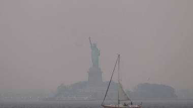 Statuia Libertății din NEw York este învăluită de un fum portocaliu, pe 6 iunie, din cauza incendiilor de vegetație din Canada.