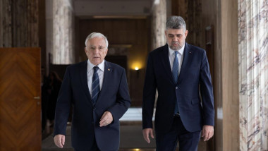 Guvernatorul BNR Mugur Isărescu și premierul Marcel Ciolacu se plimbă pe un coridor al Palatului Victoria din București pe 19 iunie 2023.