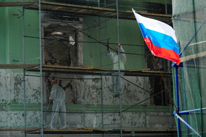 clădire acoperită de schele și un steag al Rusiei