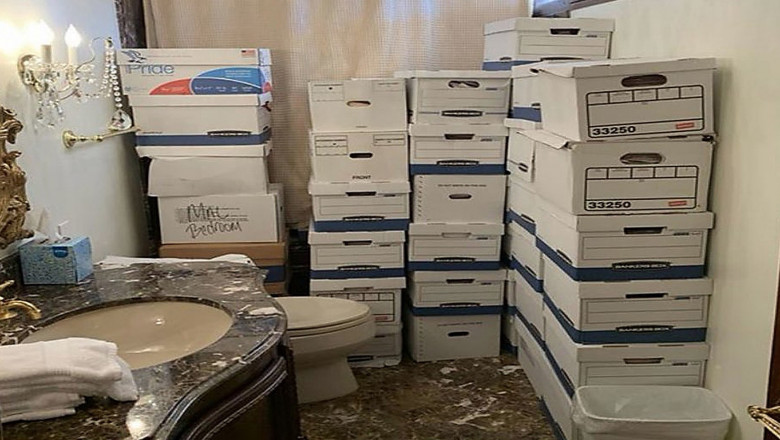 Boxes allegedly containing classified documents appear to be stored near a toilet and a shower in a gilded bathroom
