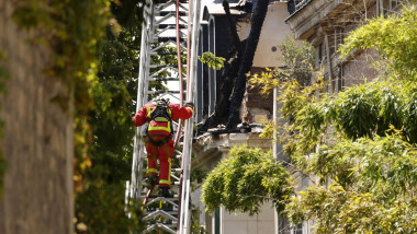Un pompier italian urca o scara la ambasada Italiei din Paris, pe 20 iulie 2021.