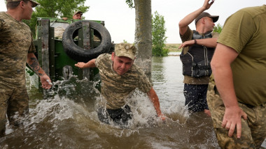 Echipaje de salvare trag o ambarcațiune într-o zonă inundată din Herson, Ucraina, pe 10 iunie, 2023.