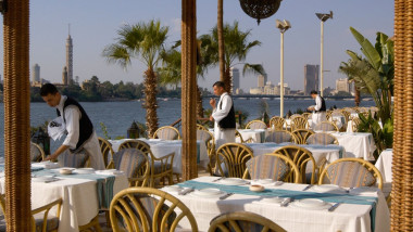 chelneri aranjeaza mesele unui restaurant cu terasa