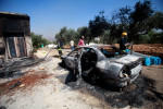A car set on fire by Israeli settlers is pictured in front of a house in Turmus Aya, near the West Bank city of Ramallah, Ramallah, West Bank, Palestinian Territory - 21 Jun 2023
