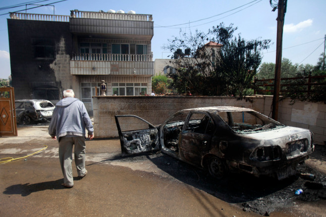 A car set on fire by Israeli settlers is pictured in front of a house in Turmus Aya, near the West Bank city of Ramallah, Ramallah, West Bank, Palestinian Territory - 21 Jun 2023