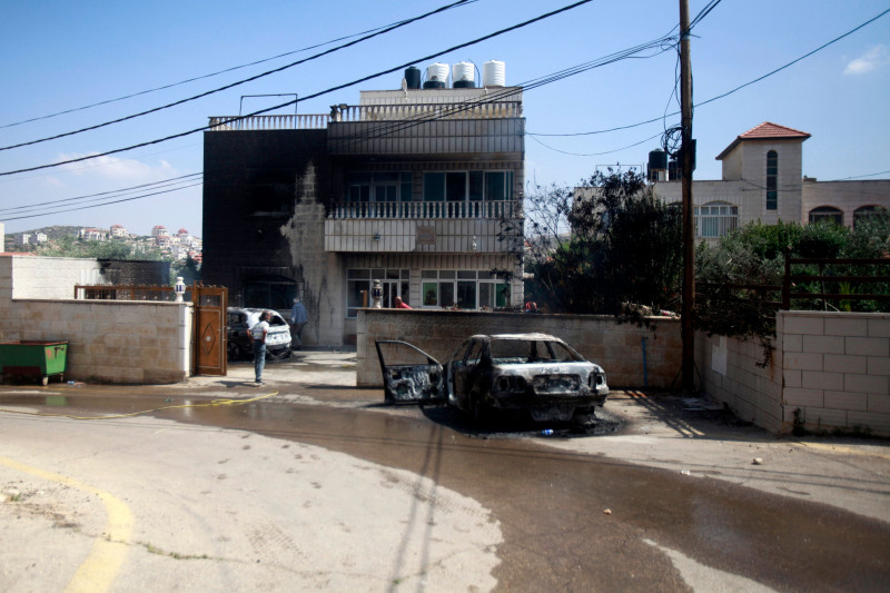 A car set on fire by Israeli settlers is pictured in front of a house in Turmus Aya, near the West Bank city of Ramallah, Ramallah, West Bank, Palestinian Territory - 21 Jun 2023