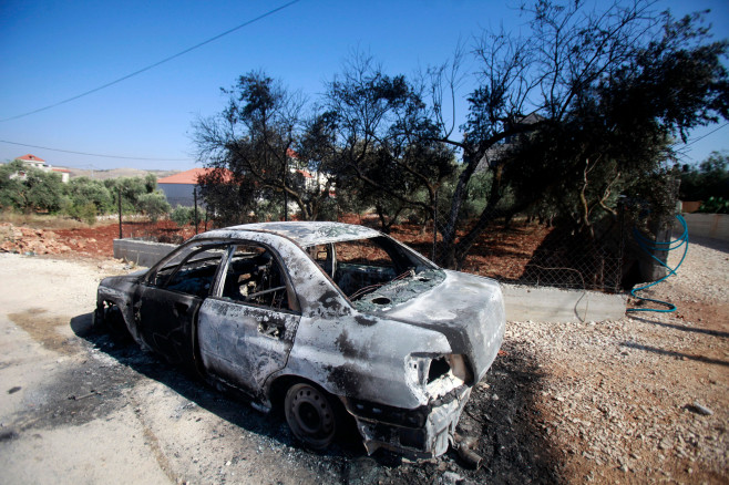 A car set on fire by Israeli settlers is pictured in front of a house in Turmus Aya, near the West Bank city of Ramallah, Ramallah, West Bank, Palestinian Territory - 21 Jun 2023