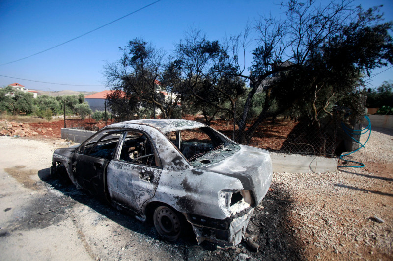 A car set on fire by Israeli settlers is pictured in front of a house in Turmus Aya, near the West Bank city of Ramallah, Ramallah, West Bank, Palestinian Territory - 21 Jun 2023