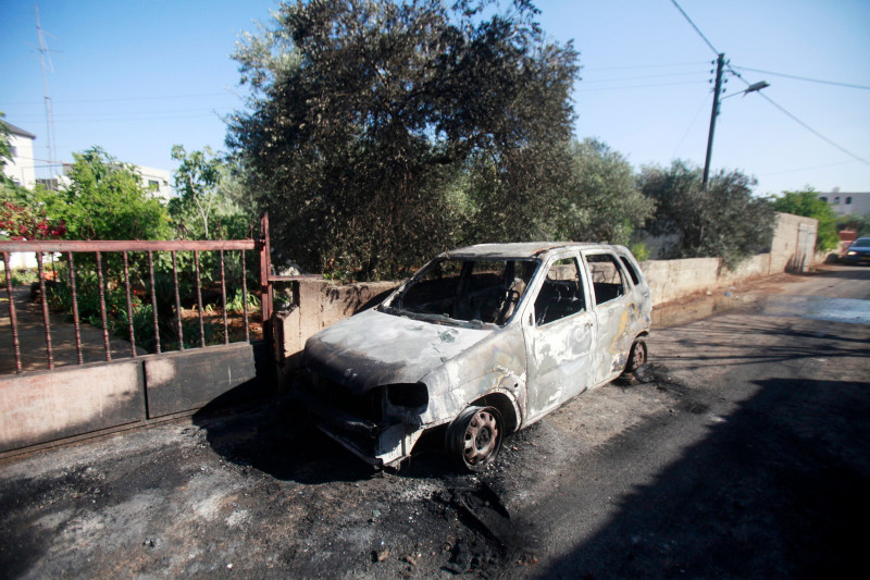 A car set on fire by Israeli settlers is pictured in front of a house in Turmus Aya, near the West Bank city of Ramallah, Ramallah, West Bank, Palestinian Territory - 21 Jun 2023