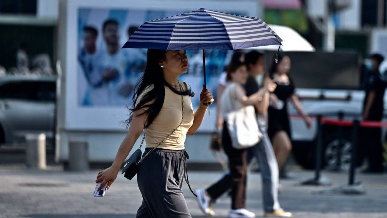 oameni care se feresc de caldura pe strada in china