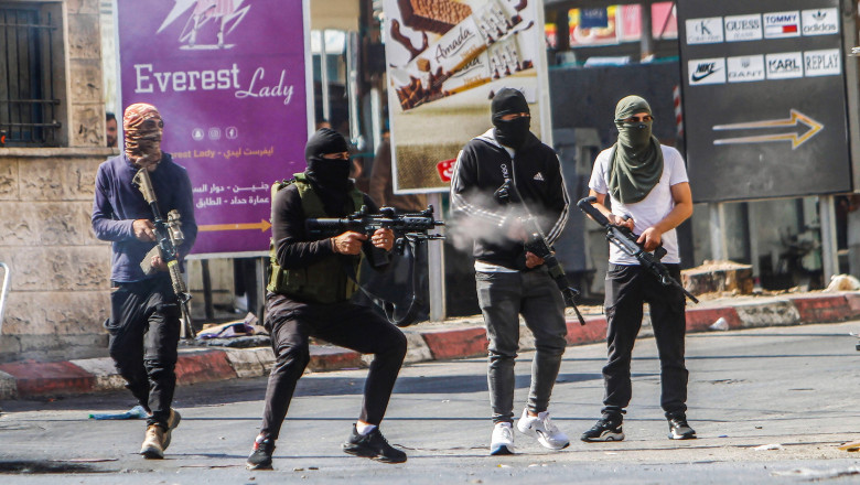 Masked armed Palestinians shooting at Israeli army forces during a raid on the Jenin