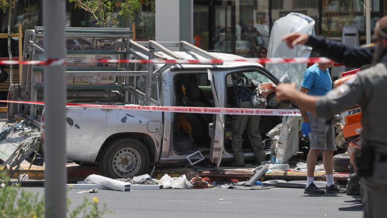 Members of Israeli security and emergency personnel work at the site of a reported car ramming attack in Tel Aviv