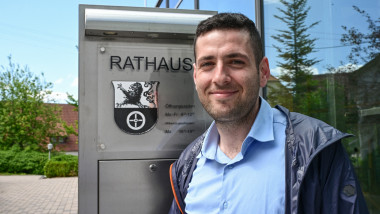 Ryyan Alshebl stands in front of the town hall in Ostelsheim