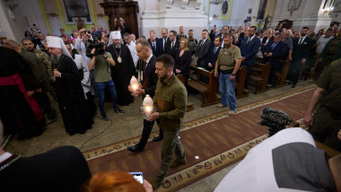 Volodimir Zelenski și Andrzej Duda in biderica cu candele aprinse, lume imprejur