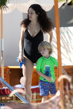 EXCLUSIVE: Mick Jagger's girlfriend Melanie Hamrick wears a black swimsuit as she relaxes by the pool with their son Deveraux Jagger in Miami