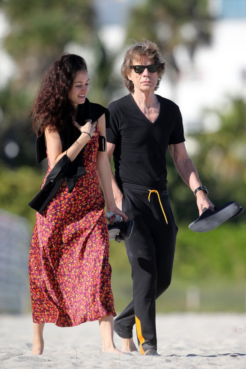 PREMIUM EXCLUSIVE: Rolling Stones frontman Mick Jagger takes his shoes off and poses for pictures during a walk on the beach with girlfriend Melanie Hamrick in Miami