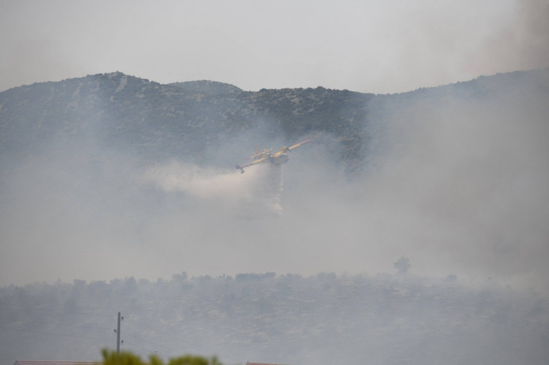 Croatia, Sibenik, 130723. Firefighters and airtankers are putting out the fire that broke out this morning in the villag