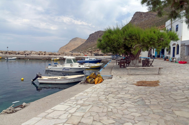 Taverna and boat / boats at the harbour at Agios Antonios,Tilos, Dodecanese, Greece. May 2022.. Spring