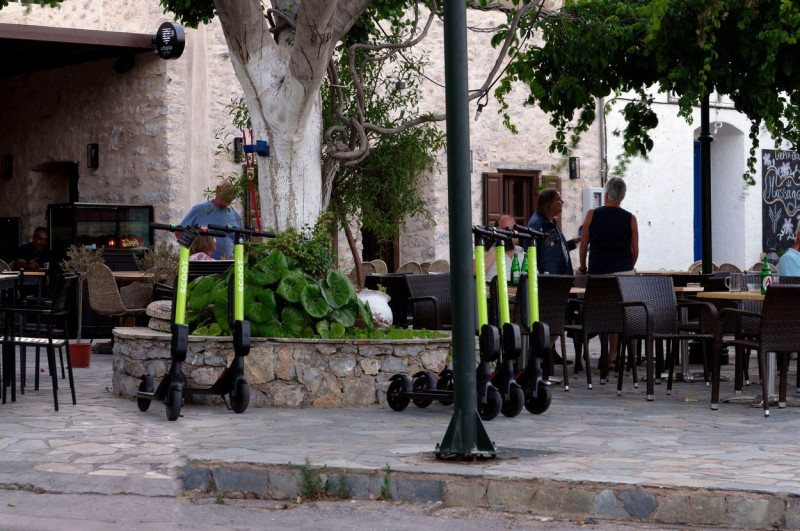 Electric hire scooters, village square, Livadia. Tilos island, Dodecanese, Greece, EU
