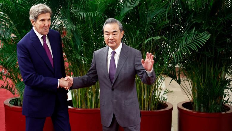 US Climate Envoy John Kerry and Director of the Office of the Foreign Affairs Commission of the Communist Party of China's Central Committee Wang Yi (R) shake hands