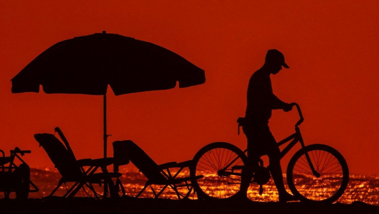 om pe plaja cu bicicleta la apus