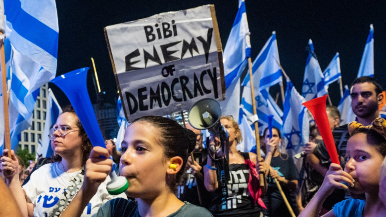 protestatari cu pancarte și steaguri în Israel
