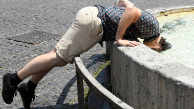 A tourist refreshes himself in a fountain at Piazza del Popolo in Rome.