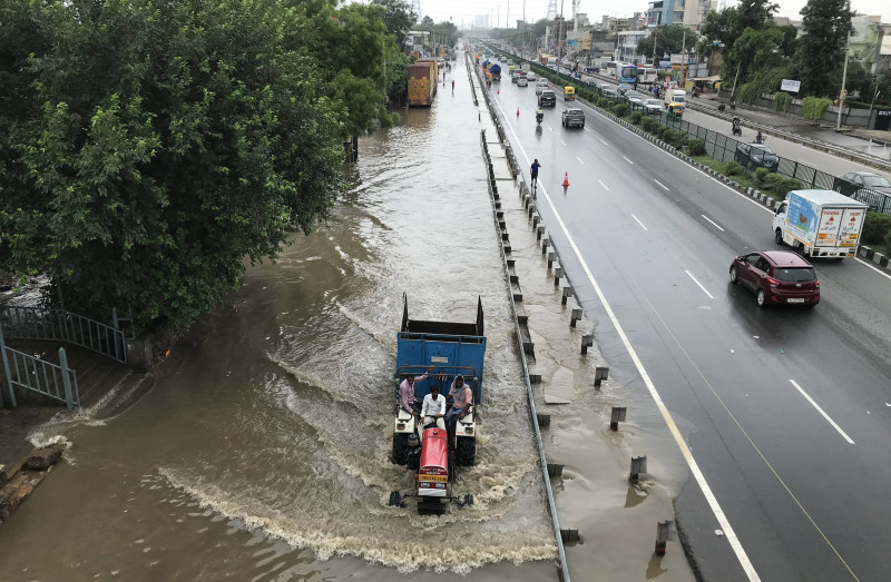 GURUGRAM, INDIA - JULY 9: Vehicles wade through a waterlogged stretch in heavy rains on the NH-48 service road near Nars