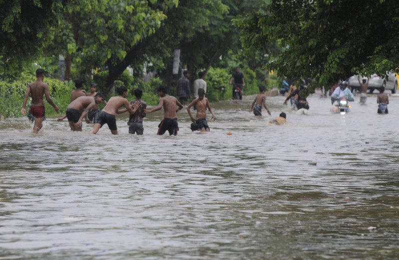 GURUGRAM, INDIA - JULY 9: Children playing on a waterlogged strech following heavy monsoon rain at sector-38 near Tau De